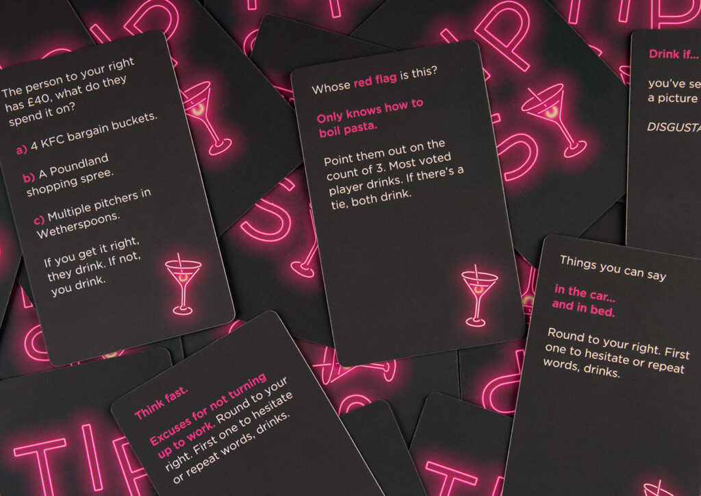 Pile of black game cards with neon pink martini glass icons and text for a drinking game