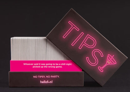 Tipsy card game box, dark with neon pink title & martini glass, open showing a stack of white cards