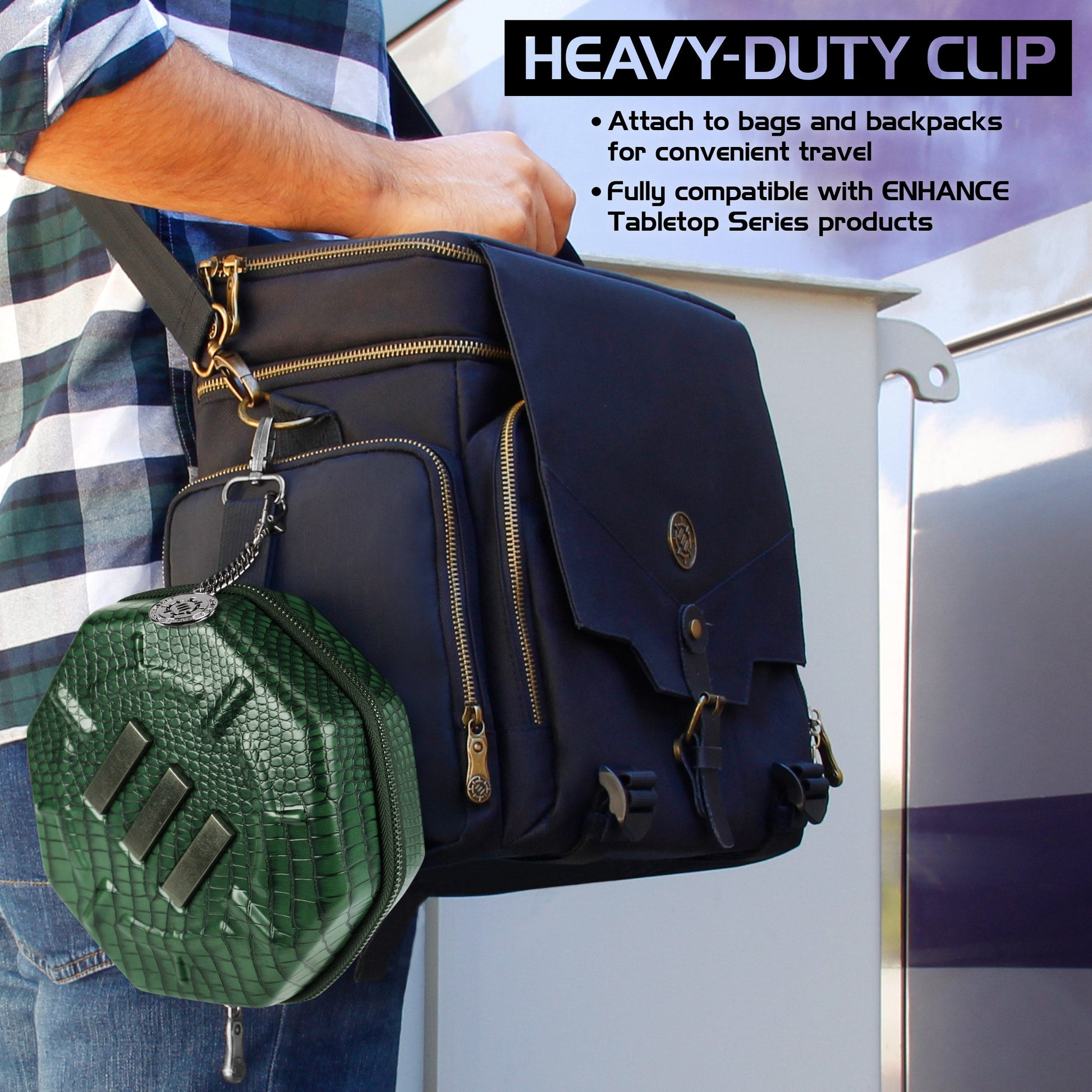 A green, scaly hexagonal case is clipped to the side of a person's dark blue messenger bag