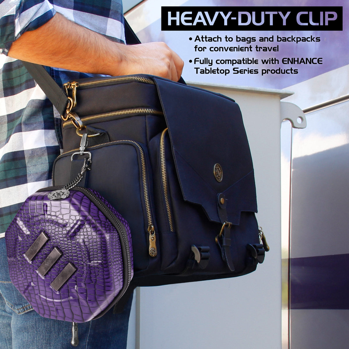 Purple, crocodile-textured case clipped to a person&#39;s black messenger bag, showcasing a heavy-duty clip for travel