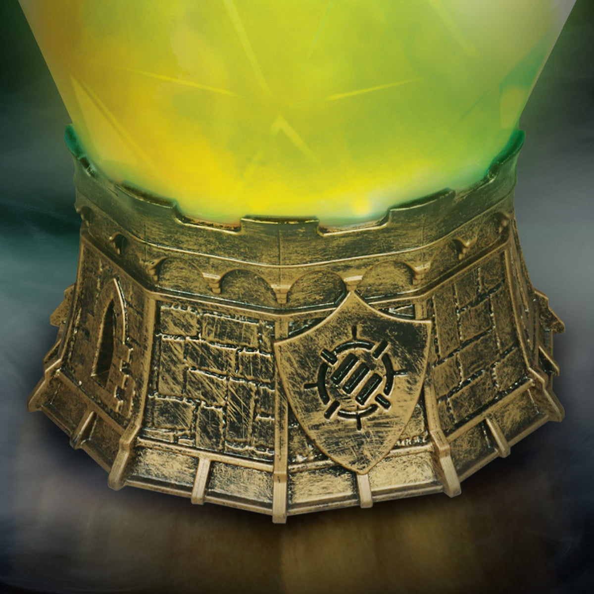 A luminous green object sits on an ornate bronze castle base, featuring brick texture, arched openings, and a shield emblem