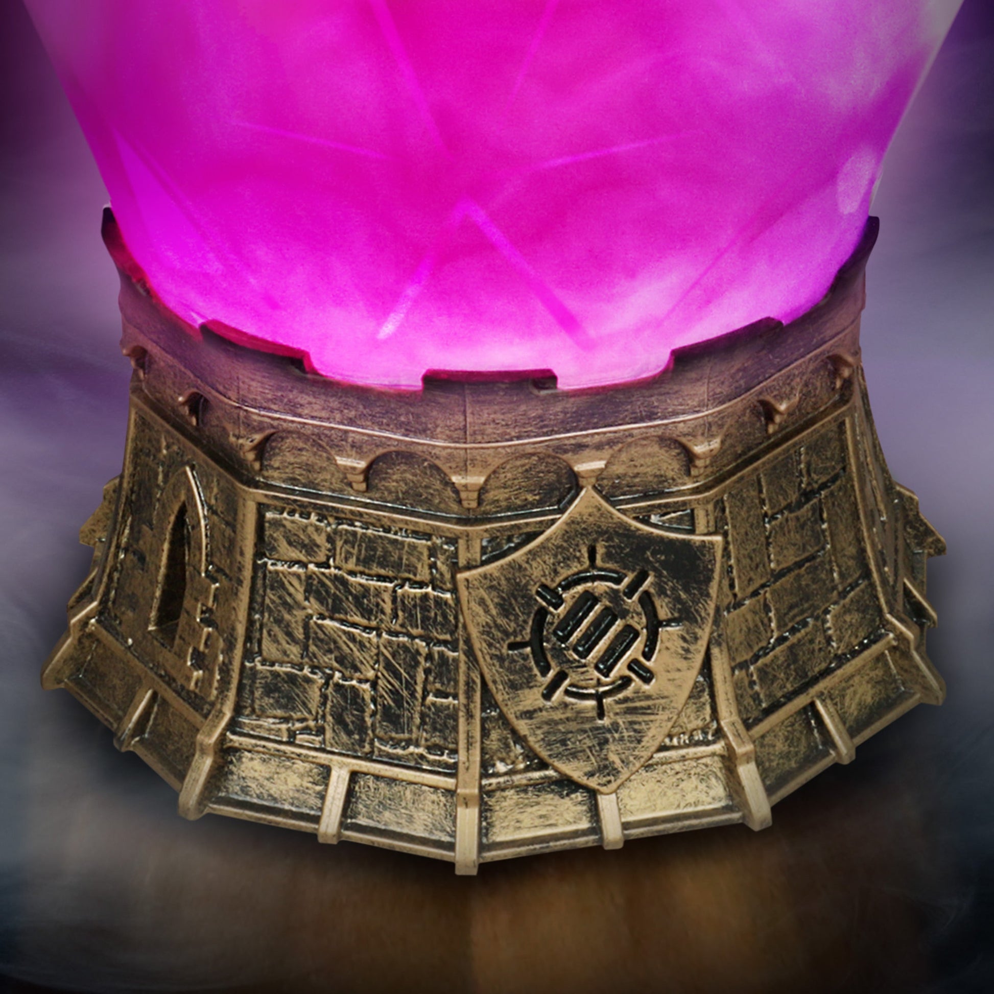 A bright pink glowing orb rests on a detailed antique gold base, resembling castle walls with a shield emblem