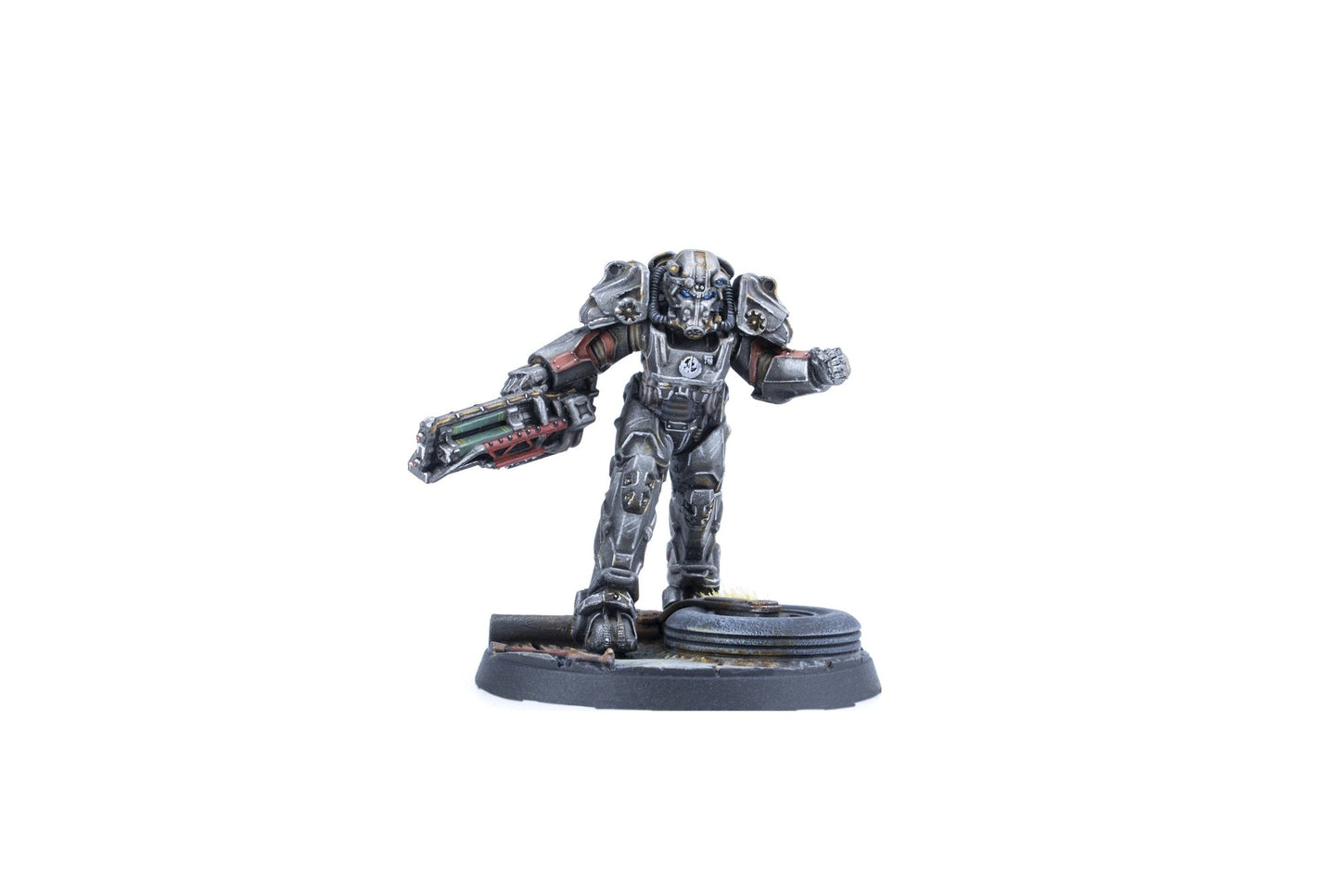 A grey armored miniature figure in power armor, holding a large sci-fi rifle, stands on a detailed base