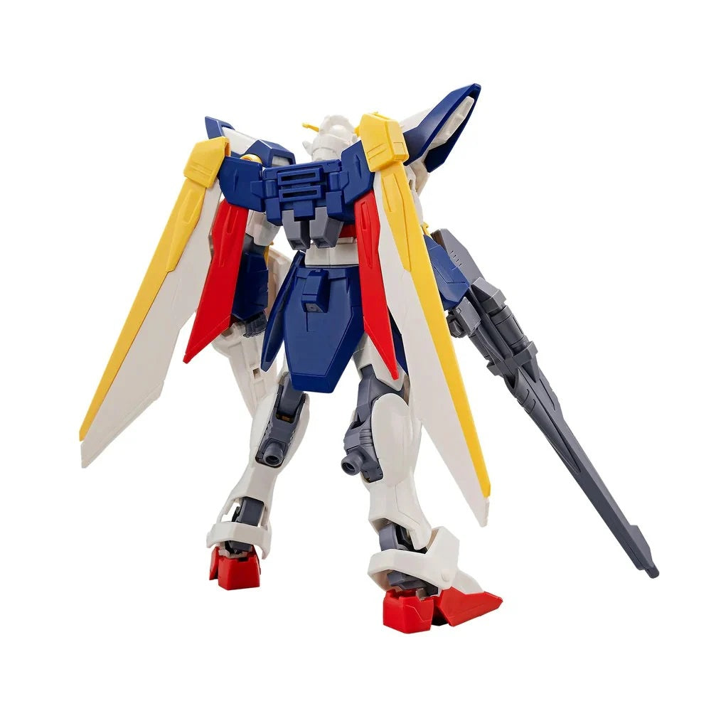 Blue, white, and yellow Gundam model from behind, with large yellow wings and holding a rifle