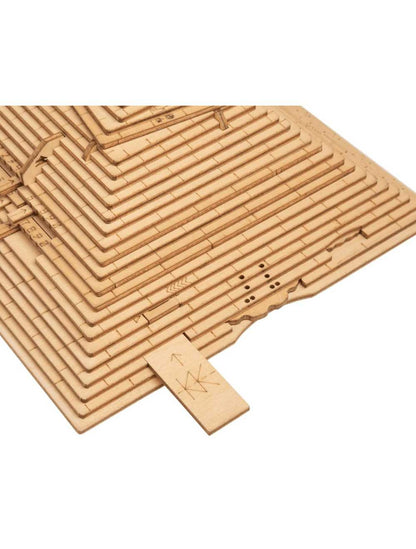 Wooden pyramid puzzle partially assembled, with a small piece marked 'KK' being inserted into a slot