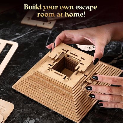 Hands with black nails assemble a multi-layered wooden escape room puzzle box on a dark table
