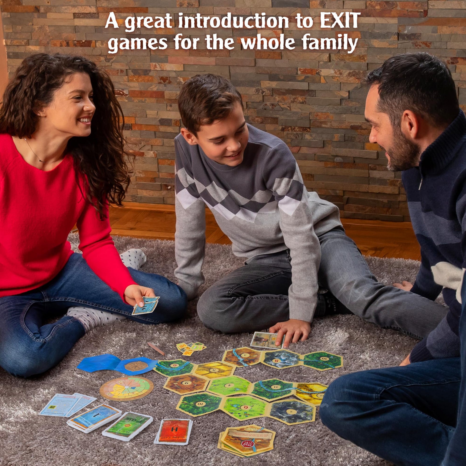 A smiling family plays Exit The Game - Adventures on Catan on a gray rug, with hexagonal landscape tiles, cards, and game pieces spread out