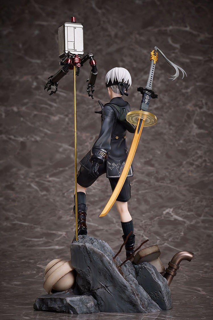 NieR Automata 9S figure with white hair and blindfold, sword on back, Pod unit on golden pole, standing on rocky debris