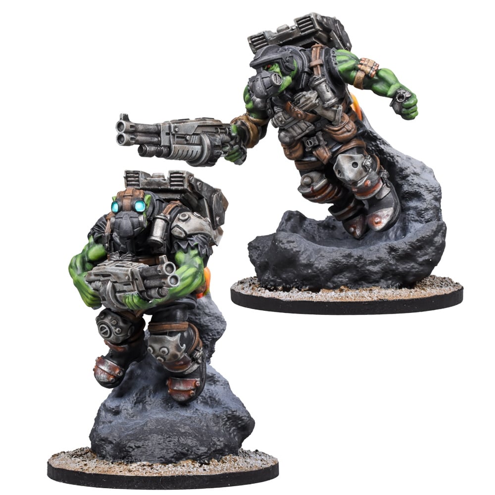 Two armored, green-skinned sci-fi miniatures. One leaps with jetpack & gun from a rock; the other stands holding a gun