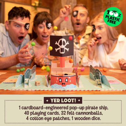 Four excited people in eye patches play a plastic-free pirate ship game, tossing felt cannonballs.