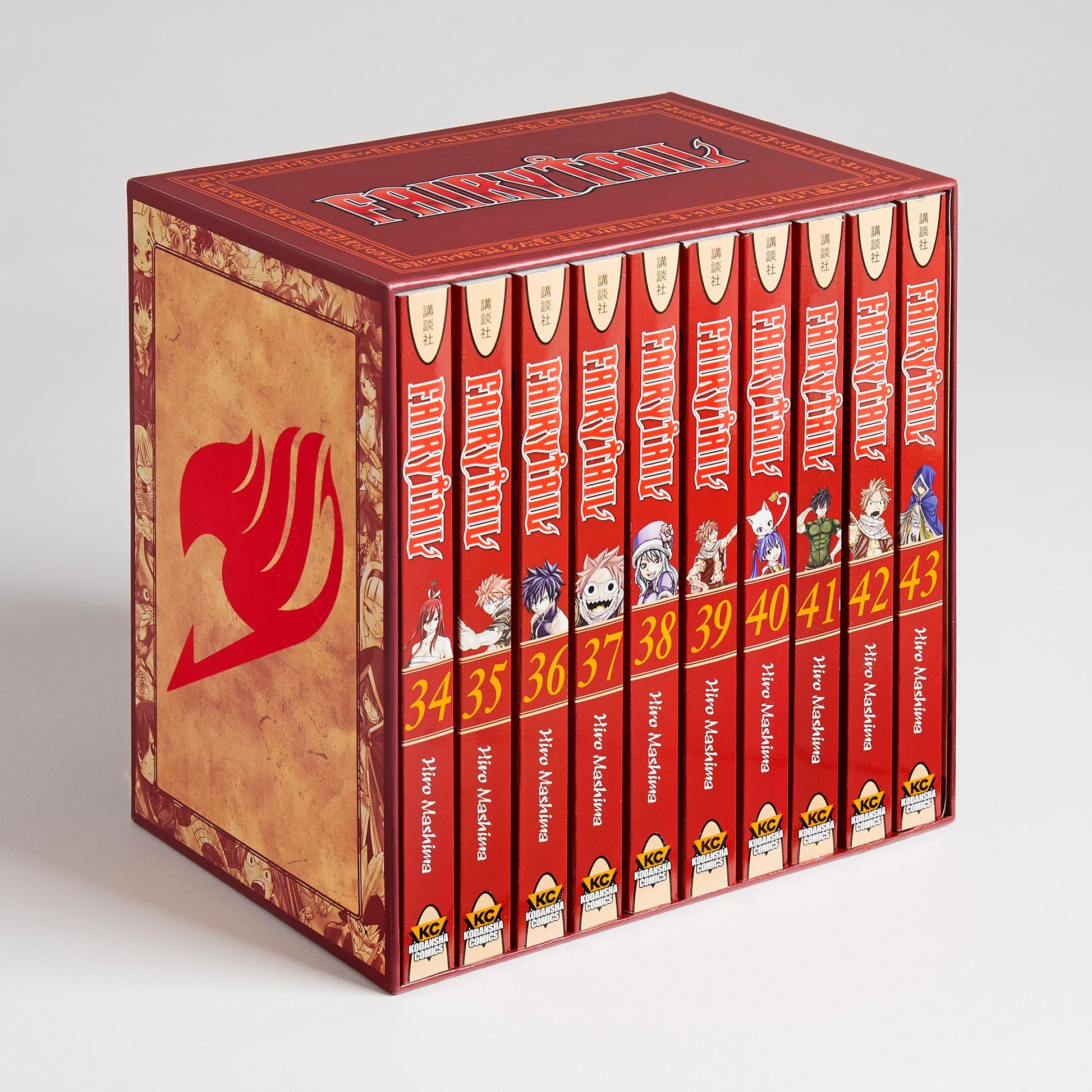 A reddish-brown Fairy Tail manga box set containing ten red volumes (34-43). The box features a large red guild logo.