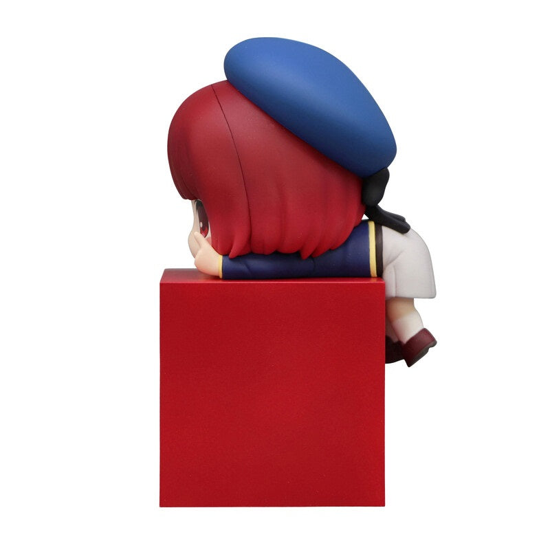 Anime figure of a girl with red hair and a blue beret perched on a red cube
