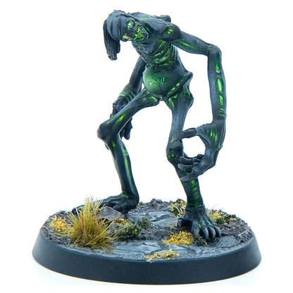 Hunched, emaciated monster miniature with glowing green veins stands on a rocky base