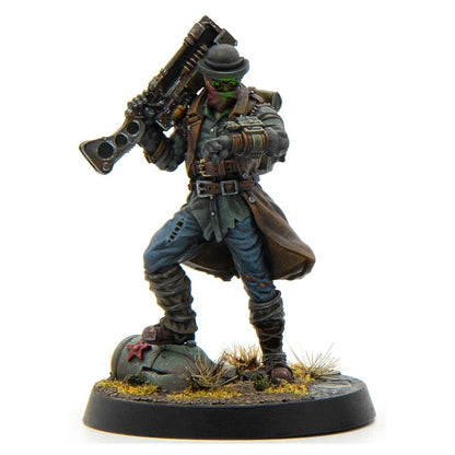 A painted miniature of a wasteland explorer in a bowler hat and green goggles, holding a rifle and checking a wrist device