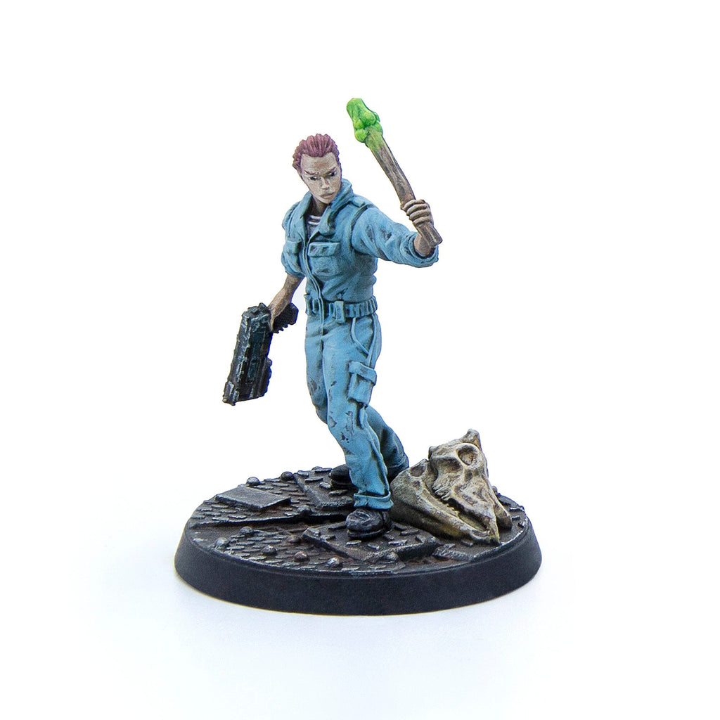 A sci-fi female miniature in a blue jumpsuit, holding a rifle and a glowing green-tipped staff, standing on a skull-strewn base