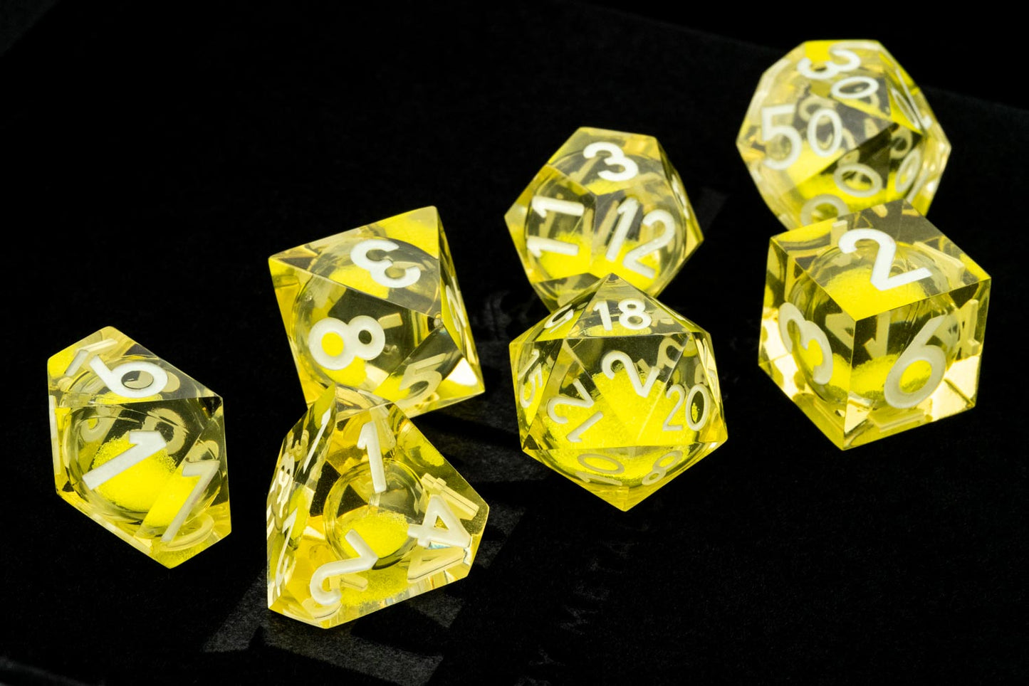 All included dice in Shadow Light UV Reactive Elixir Liquid Core RPG Dice Set in black background