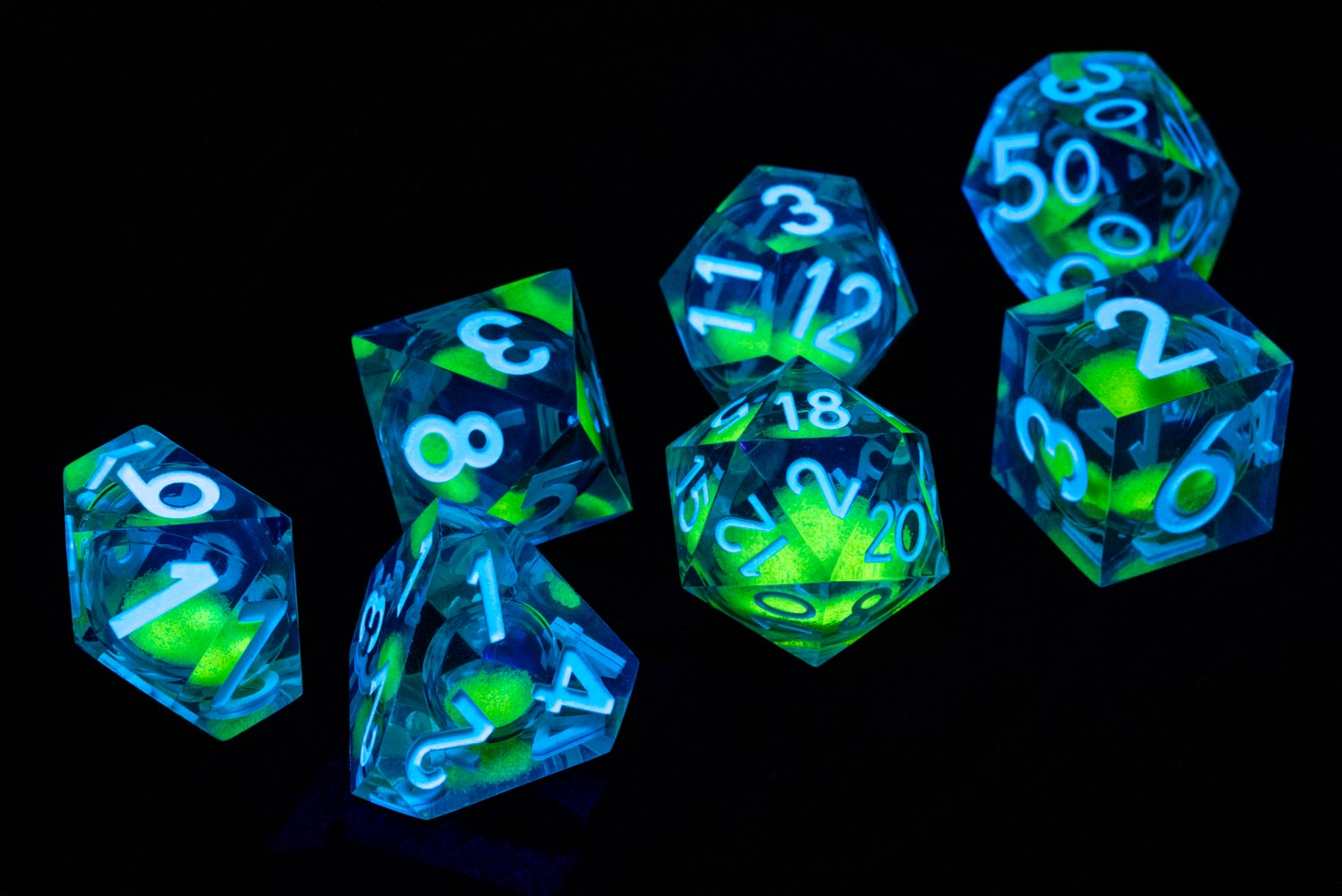 All included dice in Shadow Light UV Reactive Elixir Liquid Core RPG Dice Set in black background