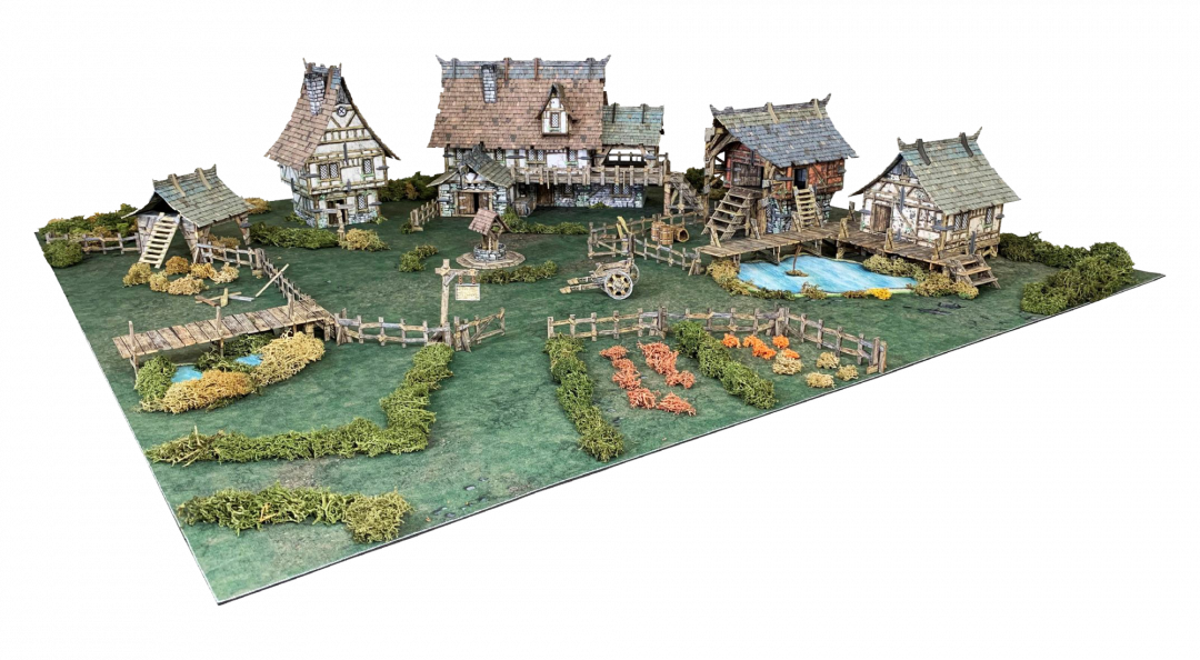 Detailed tabletop miniature medieval village diorama with half-timbered houses, fenced gardens, a well, ponds, and bridges.