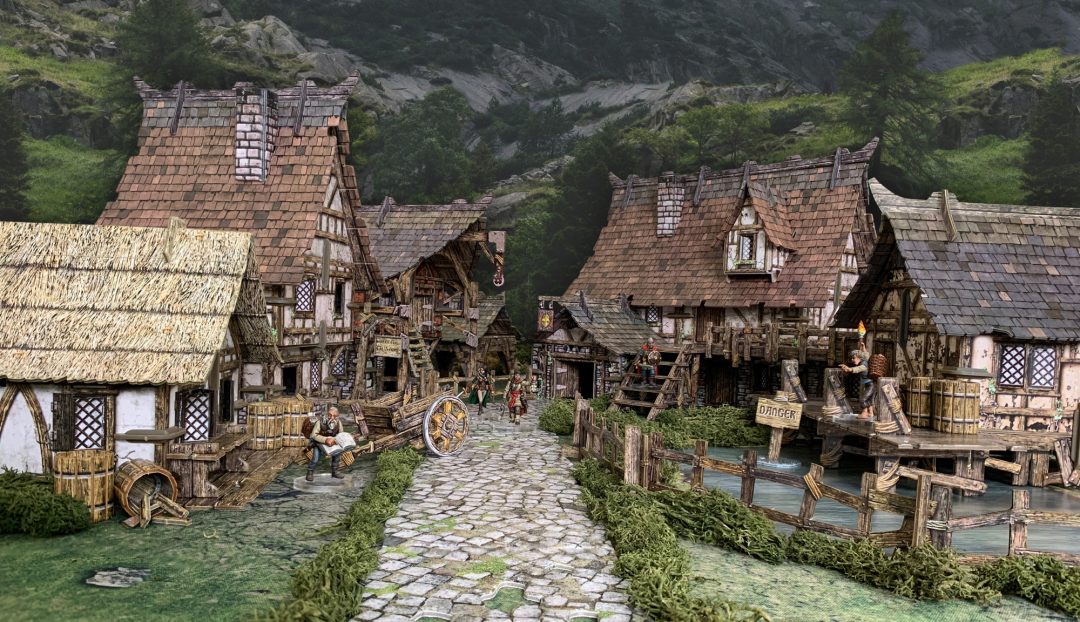 Detailed miniature medieval village diorama: cobblestone path, half-timbered houses, and miniature figures.