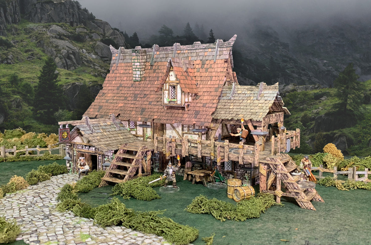 Detailed miniature diorama of &quot;The Giant&#39;s Head&quot; medieval inn, with fantasy figures, on a grassy hill before misty mountains.