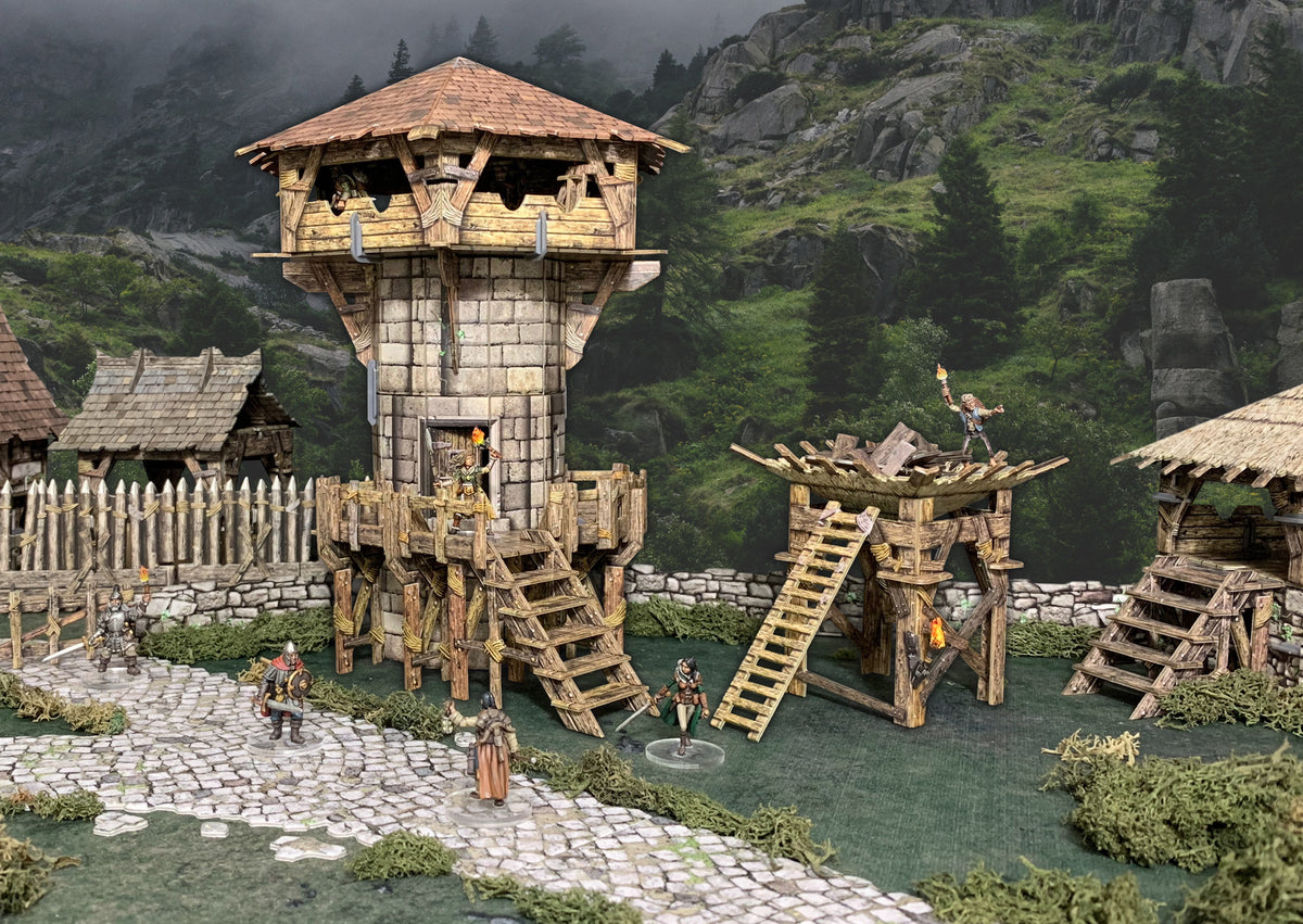 Detailed diorama of a stone guard tower with wooden platforms. Miniatures stand guard, one holding a torch, in a misty mountain village.