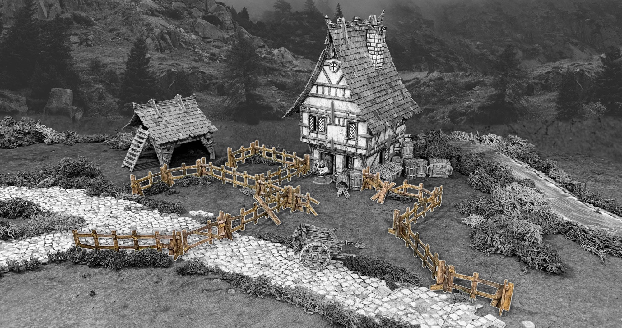Colorized miniature medieval house, shed, and fences, with a figure outside and a cart on a path. Greyscale mountain background.