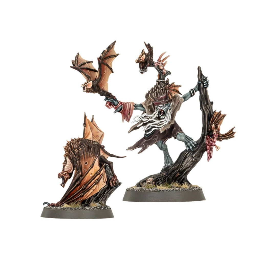 Two painted vampire-themed miniatures: a pale ghoul holding a bat on a tree and a large winged monster