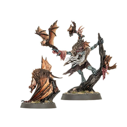 Two painted vampire-themed miniatures: a pale ghoul holding a bat on a tree and a large winged monster