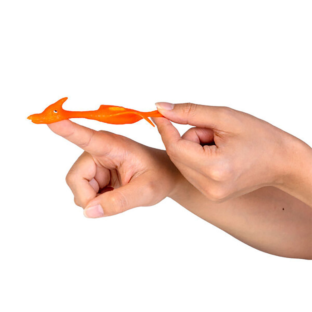 A hand stretches an orange rubber pterodactyl toy held on a finger, ready to launch