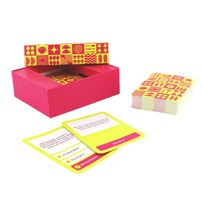 A pink trivia game set with a patterned lid, a stack of cards, and two visible food/drink question cards