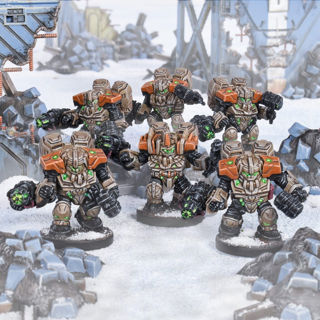 Six armored sci-fi miniatures with tan, orange and black suits and glowing green eyes stand on snow amidst ruins