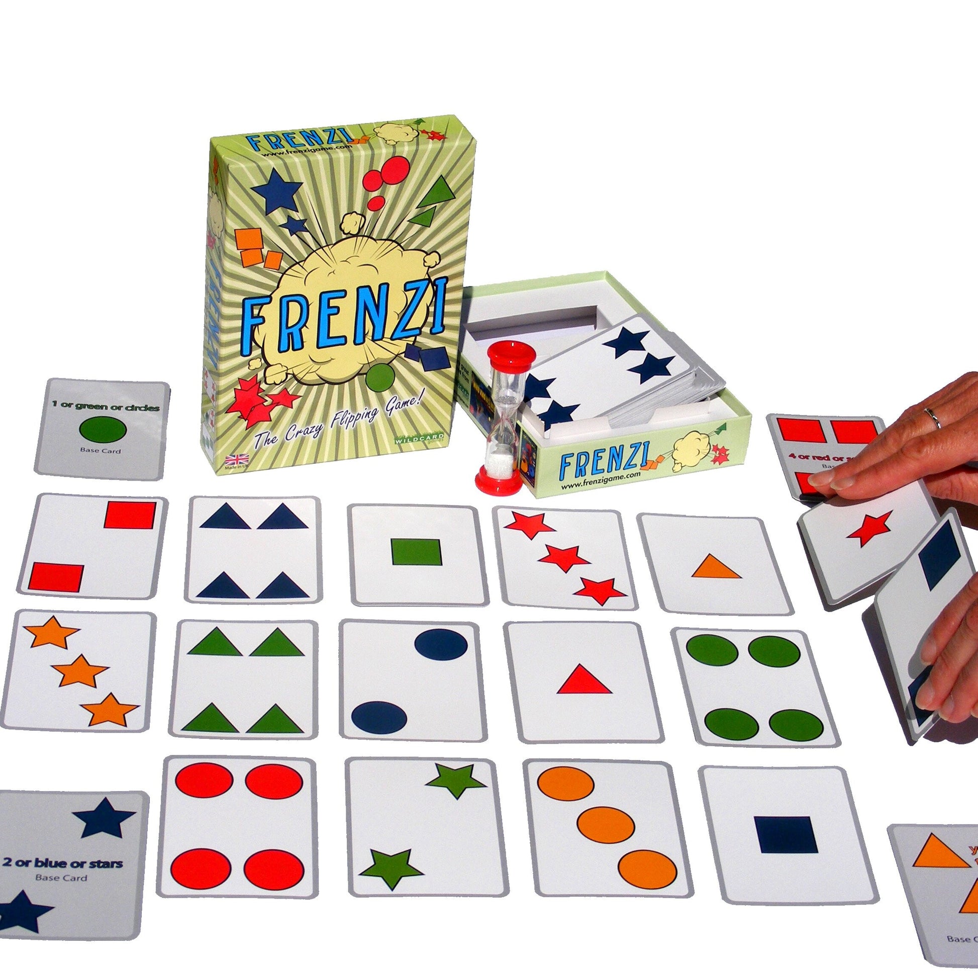 FRENZI card game set with box, hourglass, and multiple cards showing colorful shapes. A hand holds game cards