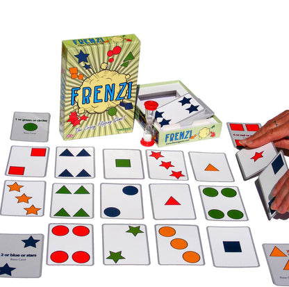 FRENZI card game set with box, hourglass, and multiple cards showing colorful shapes. A hand holds game cards