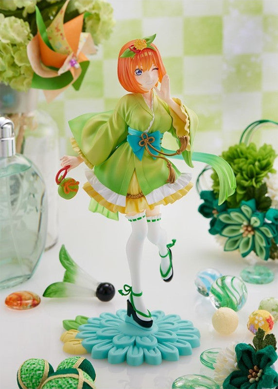 Orange-haired anime figure in a bright green floral print kimono and light blue obi sash standing on a blue flower base