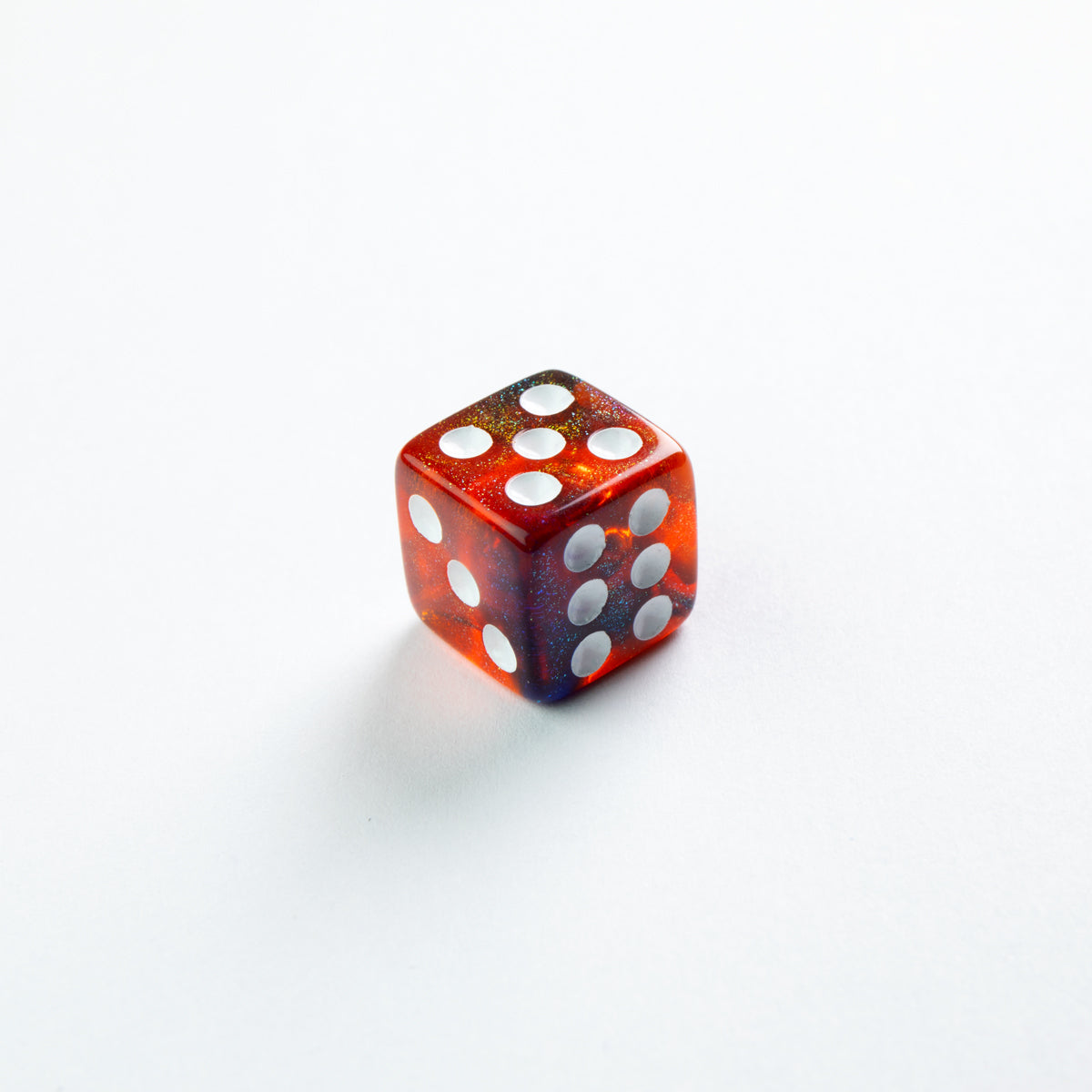 Gamegenic Galaxy Series Mars D6 set a translucent red and blue swirled dice with white pips angled on a white surface