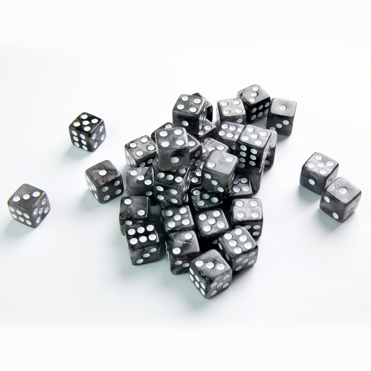 Gamegenic Galaxy Series Moon 12mm d6 dice set in shimmering black with white pips scattered on a white surface