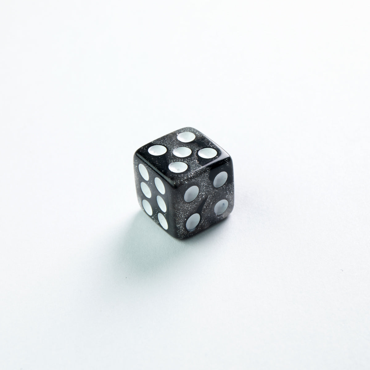 Gamegenic Galaxy Series 12mm D6 set Moon a single black glitter-flecked die with white pips showing 6, 5, and 4