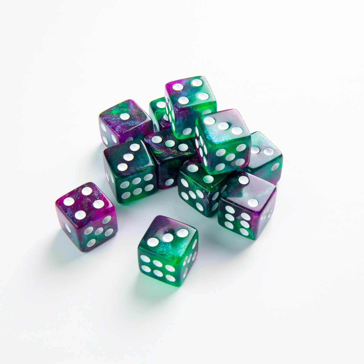 Gamegenic Galaxy Series Aurora 16mm D6 dice set translucent purple and green glitter dice with white pips scattered on a white surface