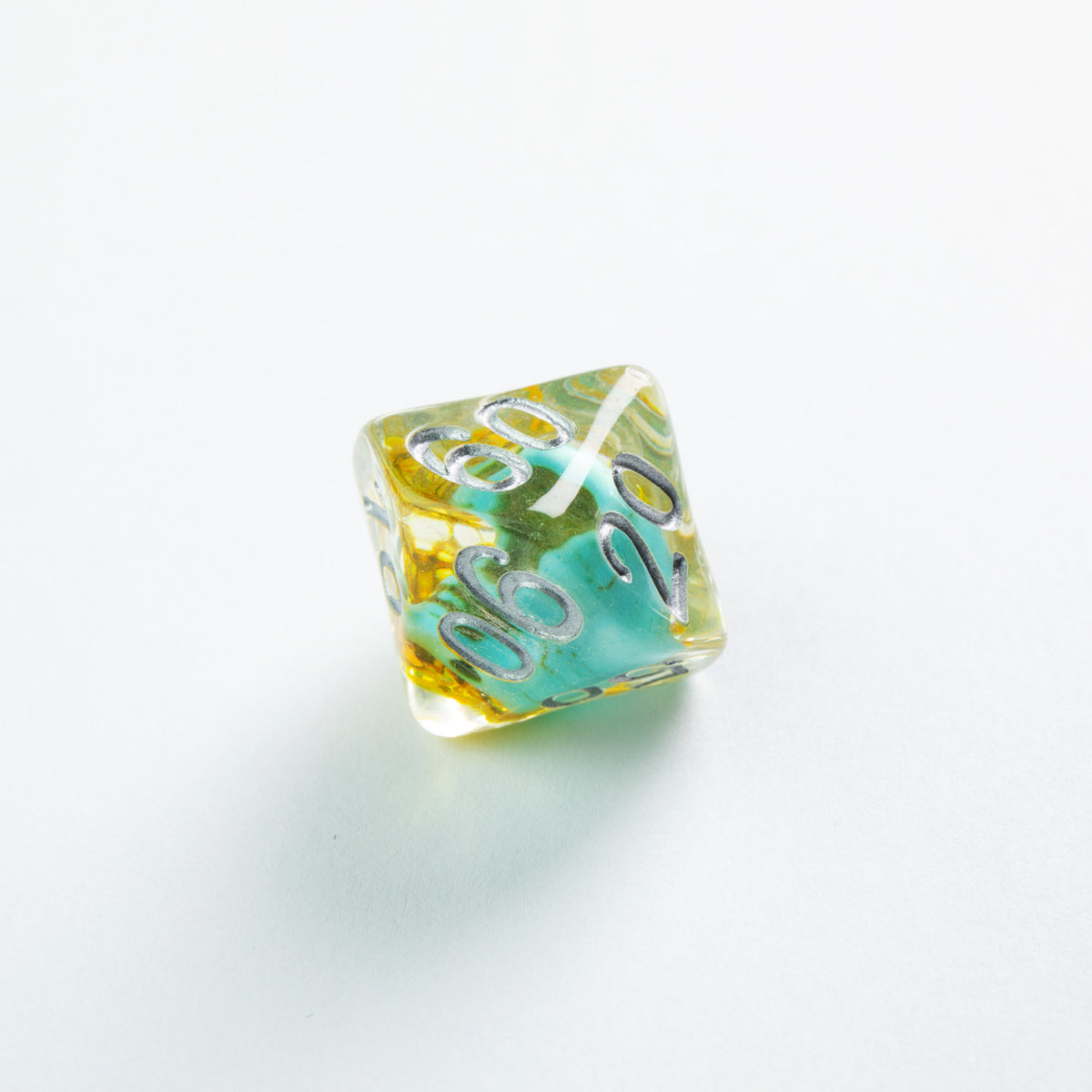 Translucent yellow and turquoise percentile die with silver numbers 60 and 20, on a white background