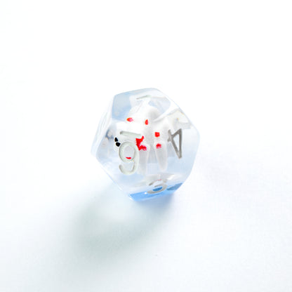 Clear and blue d20 die with a tiny, blood-splattered white skeleton inside, on a white surface
