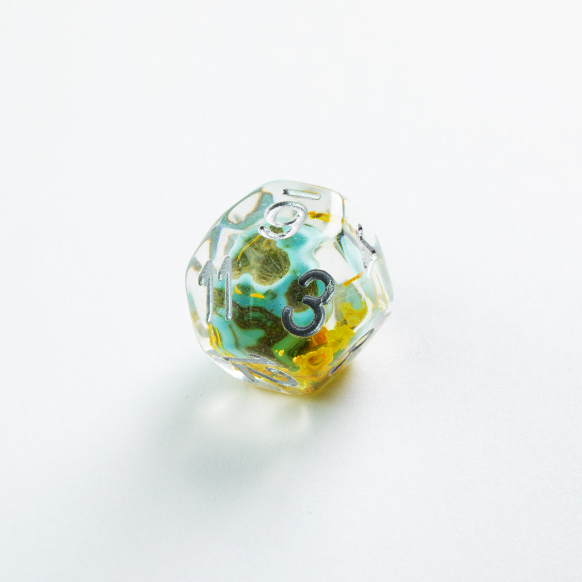 Transparent d20 RPG die with swirls of teal, yellow, and green, displaying silver numbers 3, 9, and 11 on a white background