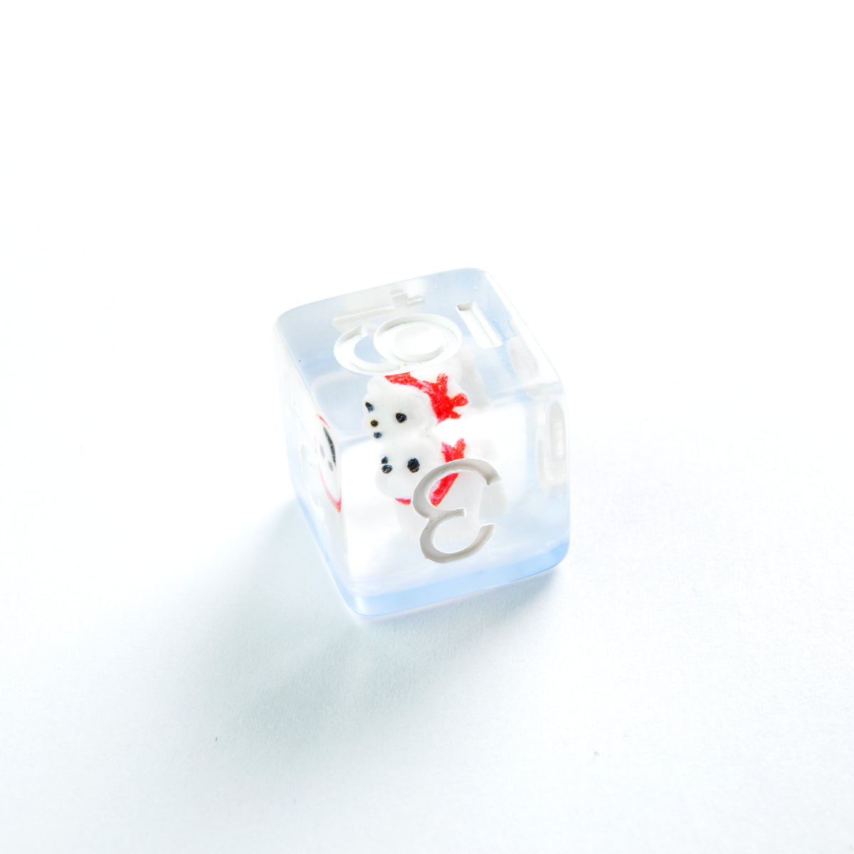Clear light blue die with two stacked white snowmen, the top one wearing a red bow, light grey letters and numbers are visible on its sides