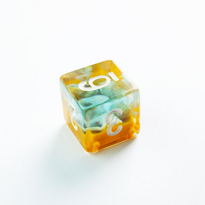 Swirling orange and teal resin die (D6) with white numbers on a white background