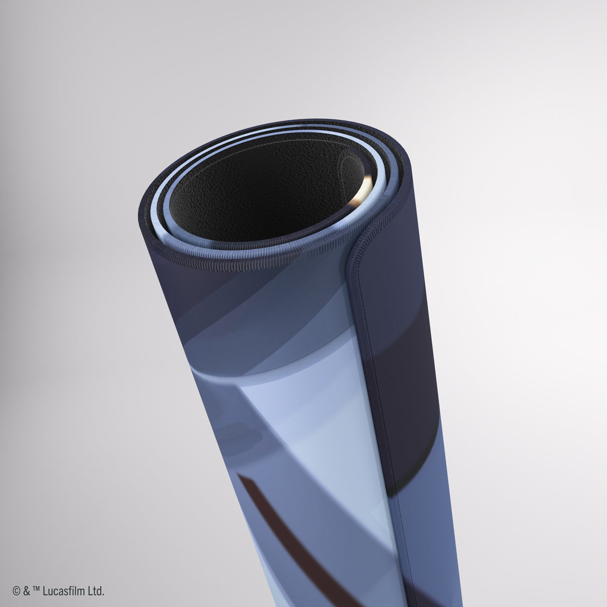 A rolled-up mat with an abstract blue and white design, showing its dark underside and stitched edge