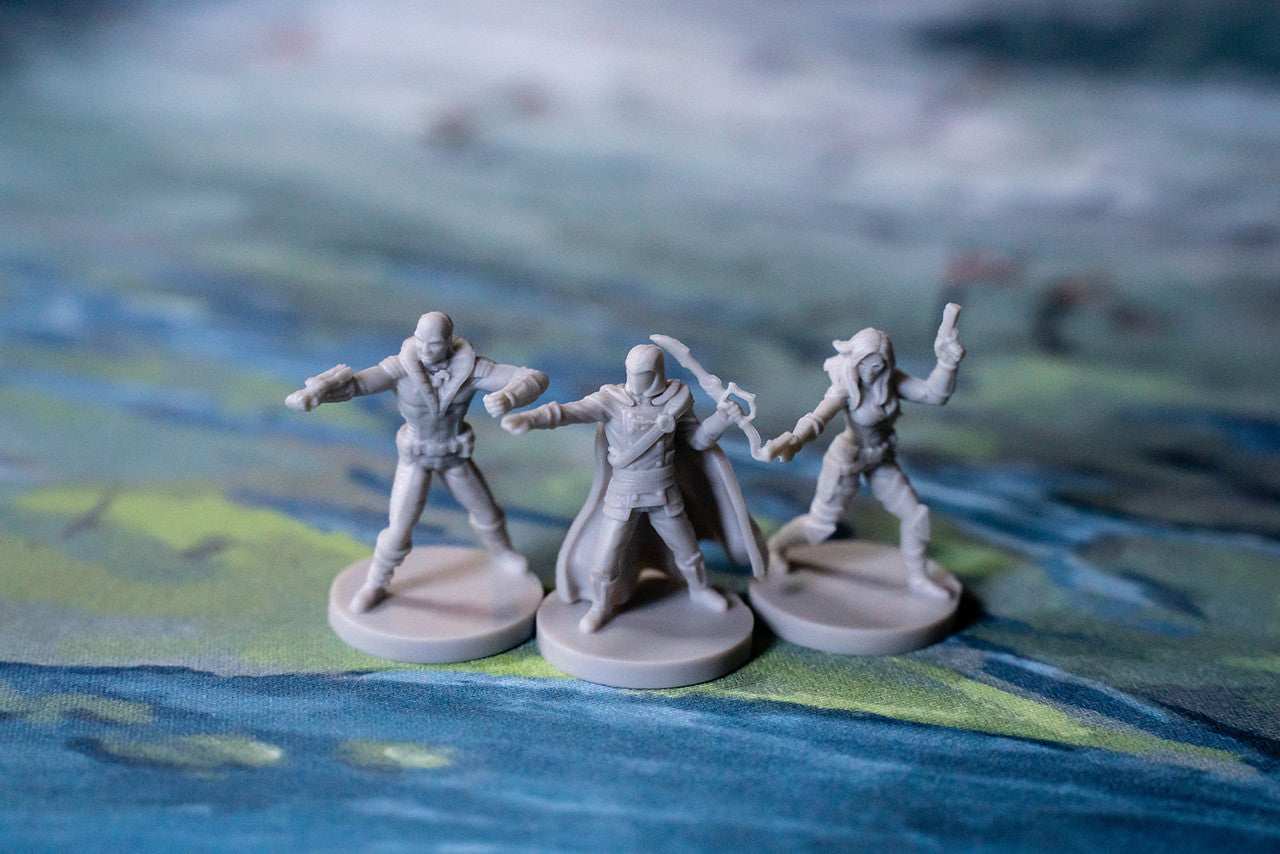 Three gray sci-fi miniature figures on a green and blue battle mat