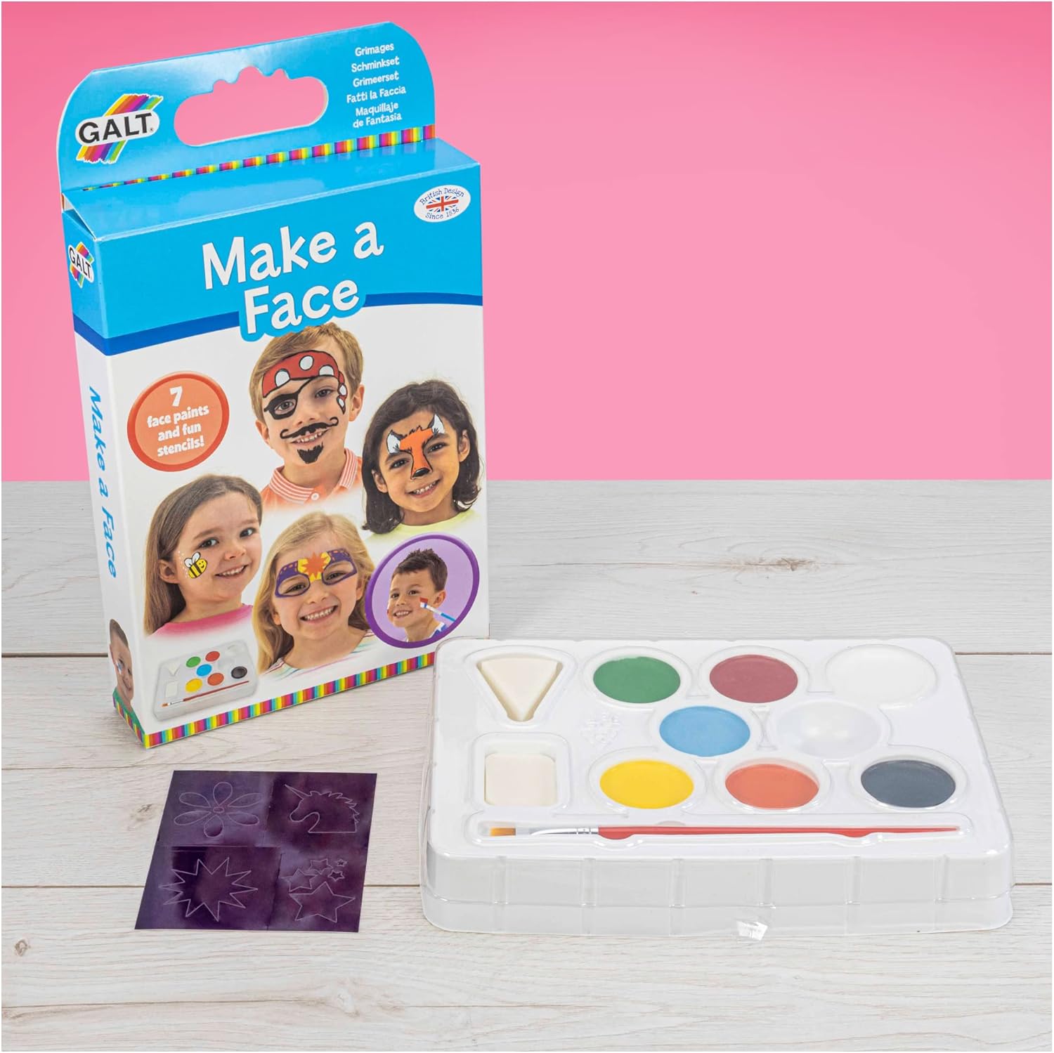 Galt Make a Face painting kit with 7 colors, brush, sponges, stencils, and box on a wooden table with pink background