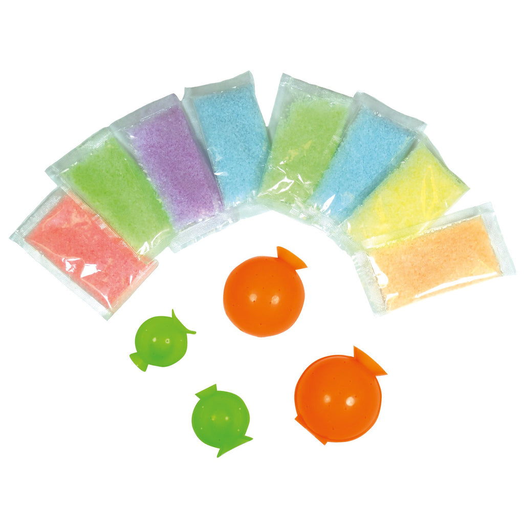 Eight packets of colorful granules and four green and orange sphere molds