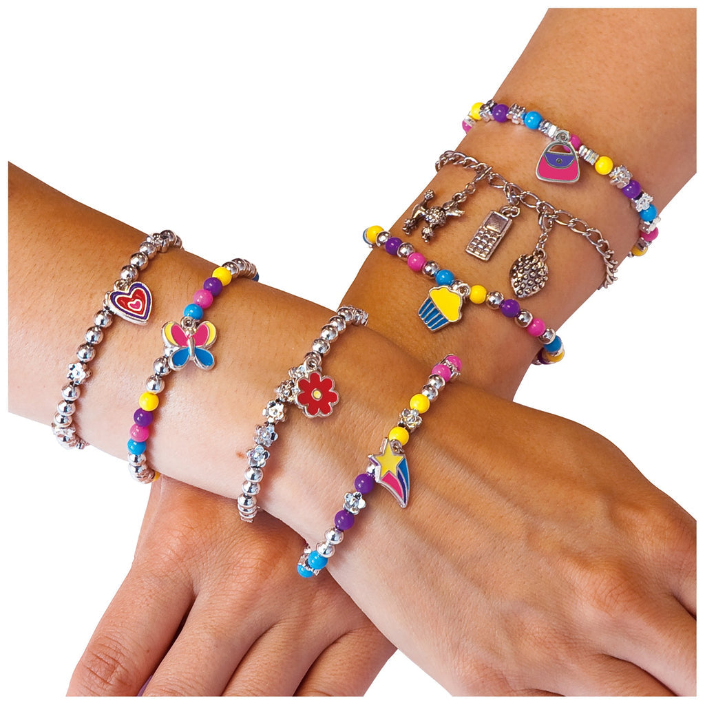 Hands adorned with multiple vibrant beaded bracelets, featuring novelty charms like butterflies, cupcakes, and a purse