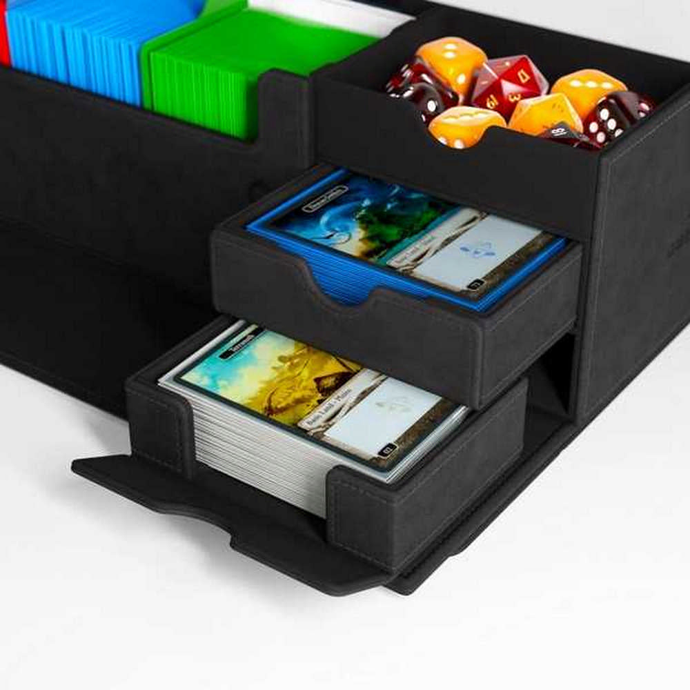 Black TCG organizer with open drawers holding sleeved cards, and a top compartment full of red and orange dice