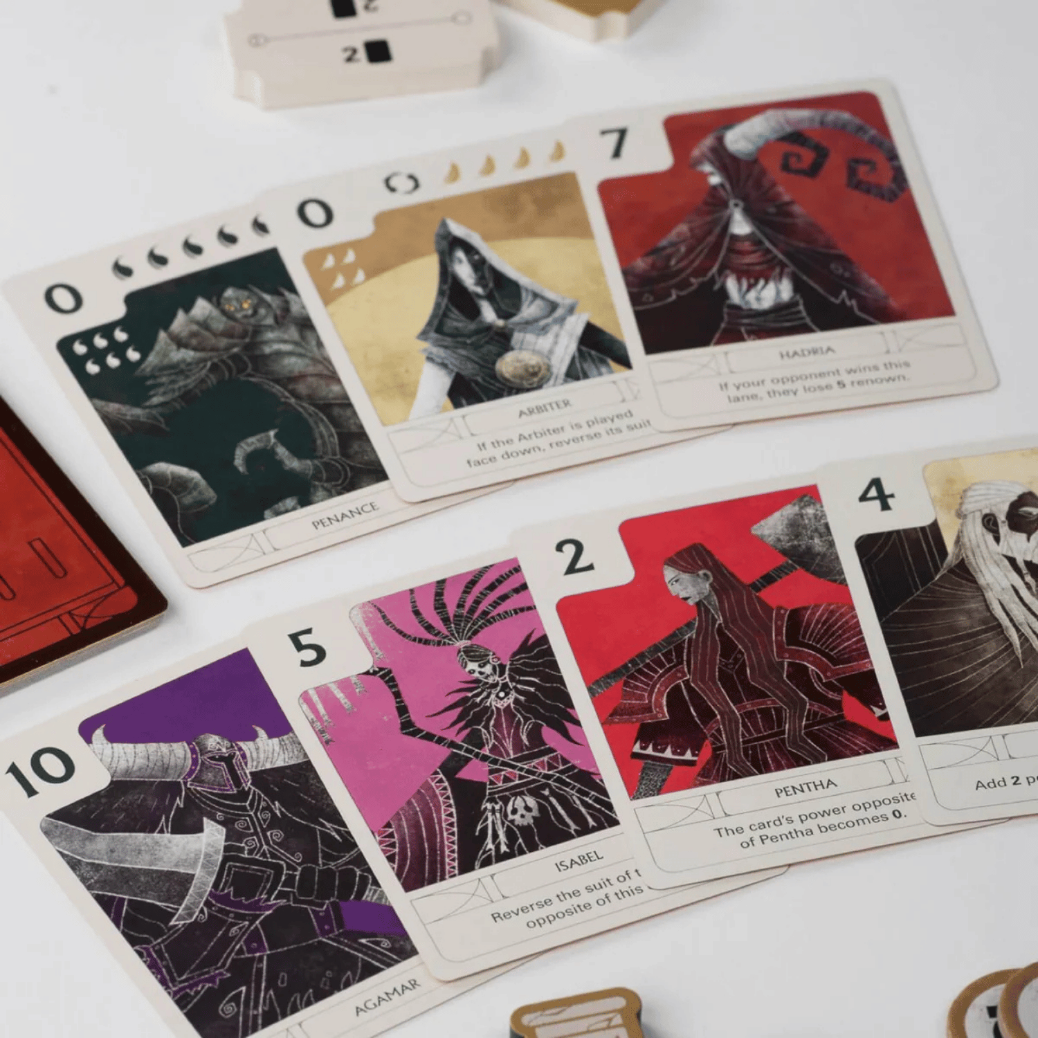 A spread of stylized dark fantasy tabletop game cards showing characters and numerical power values